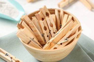 Beyaz arka planda bir kase ahşap mandal.