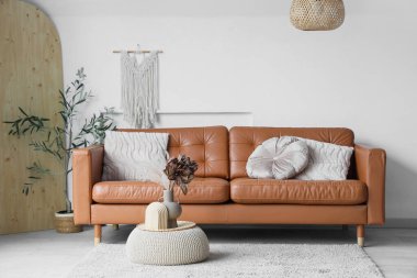 Kahverengi kanepeli, aydınlık oturma odasının içi ve puf.