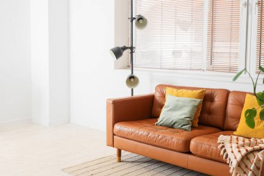 Kahverengi kanepe ve lambayla oturma odasının içinde.