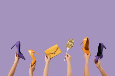 Balondan yapılmış 8 figürlü kadın elleri, şık topuklu ayakkabılar ve mor arka planda çanta. Uluslararası Kadınlar Günü kutlamaları