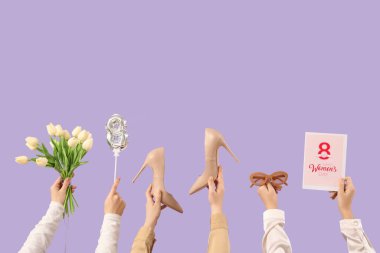 Balondan, çiçeklerden, tebrik kartından ve mor arka planda şık aksesuarlardan yapılmış 8 figürlü kadın elleri. Uluslararası Kadınlar Günü kutlamaları