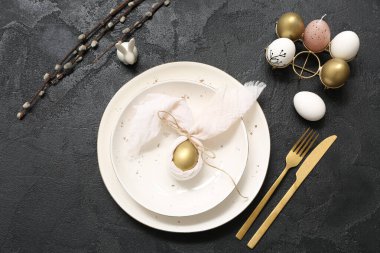 Beautiful table setting with Easter eggs and pussy willow branches on black background