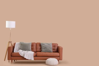 Rahat kanepe, lamba ve bej arka planda puf.