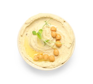 Beyaz zemin üzerinde nohut ve mikro yeşil olan lezzetli humus kasesi.