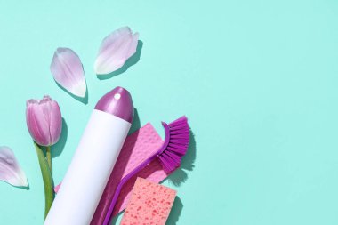 Yeşil arka planda bahar çiçeğiyle temizlik malzemeleri