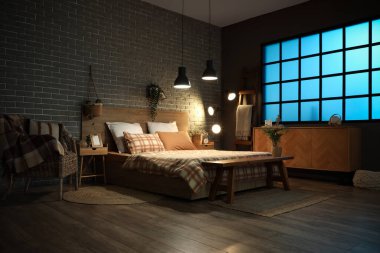 Geceleri odada fotoğraf çerçevesi olan büyük, rahat bir yatak ve masa.