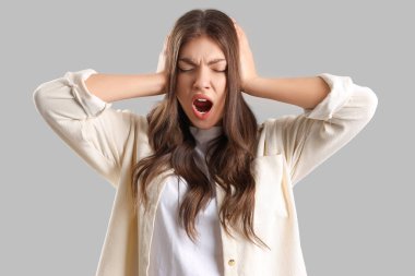 Çığlık atan genç bir kadın arka planda panik atak geçiriyor.