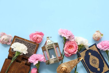 Kur 'an' lı fanatikler ve mavi arka planda güzel çiçekler. Ramazan kutlaması