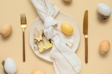 Paskalya yumurtaları ve bej arka planda ahşap tavşanla güzel bir masa.