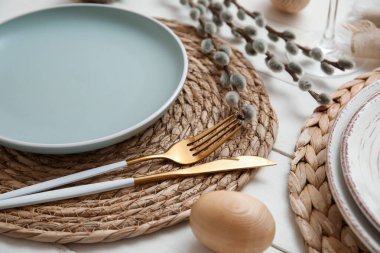 Beautiful table setting with Easter egg and pussy willow branches on white wooden background, closeup