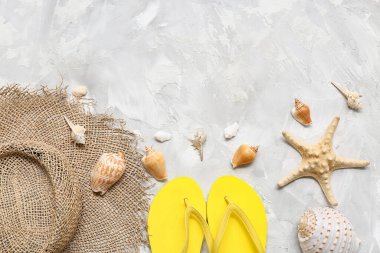 Parmak arası terlikli yaz şapkası ve grunge arkaplanda deniz kabukları