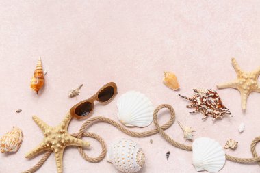 İp ve deniz kabuklu güneş gözlükleri pembe grunge arka planda