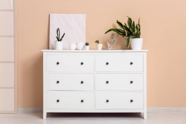 Odadaki bej duvarın yanında içi sulu ve dekorlu çekmeceler.