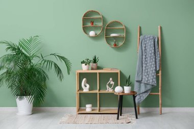 Salonun içinde raf ünitesi, merdiven ve yeşil bitkiler var.