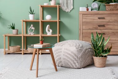 Oturma odasının içinde masa, raf ünitesi ve sulu