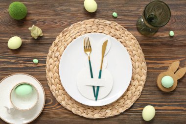 Paskalya yumurtaları ve tahta arka planda oyuncak tavşanla güzel bir masa.