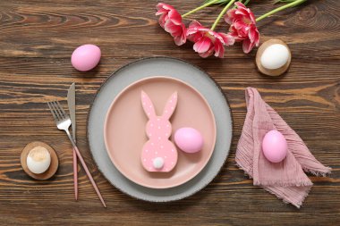 Paskalya yumurtaları, tavşancık ve ahşap arka planda lale çiçekleri olan güzel bir masa.