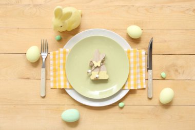 Paskalya yumurtaları ve ahşap arka planda tavşanlarla güzel bir masa.