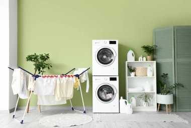 Çamaşır makinesi, raf ünitesi ve kurutuculu çamaşır odasının içi.