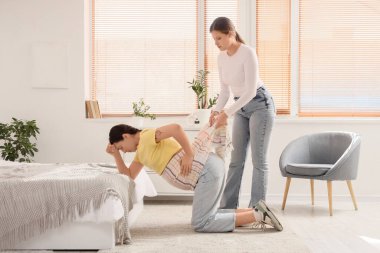 Eşarplı genç Doula hamile kadına yatak odasında masaj yapıyor.