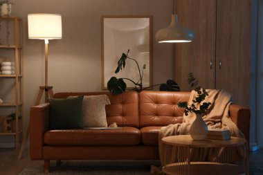 Rahat kanepesi, sehpası ve geceleri parlayan lambaları olan şık bir oturma odası.