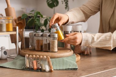 Mutfakta elinde baharat kavanozu olan kadın, yakın plan.