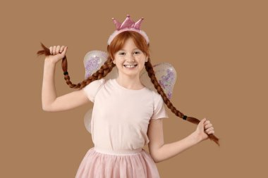 Kahverengi arka planda örgüleri olan sevimli kızıl saçlı peri.