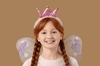 Kahverengi arka planda sevimli kızıl saçlı peri, yakın plan.