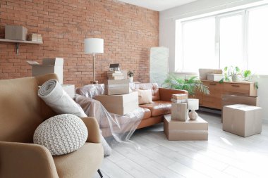 Taşındığı gün oturma odasında karton kutuları olan koltuk ve koltuk.