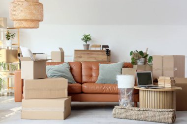 Taşındığı gün oturma odasında minderli ve karton kutulu kanepe.