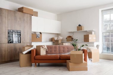 Taşındığı gün hafif mutfakta film ve karton kutularla dolu bir kanepe.