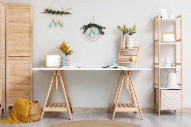 Paskalya için dekore edilmiş hafif ofisin içinde çalışma yeri ve raf ünitesi var.