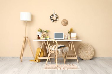 Ofiste bej duvarın yanında boş laptop ve Paskalya dekoru olan bir işyeri.