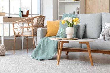 Paskalya için dekore edilmiş oturma odasının içi kanepe ve masalarla dolu.