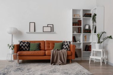 Oturma odasında ekoseli ve yastıklı rahat bir kanepe.