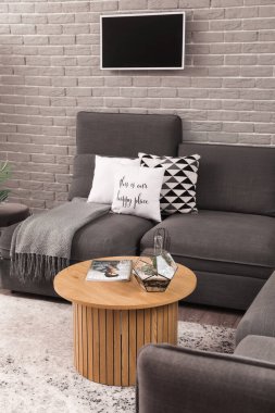 Kahve masasında rahat koltukları ve floraryumu olan modern oturma odasının içinde.