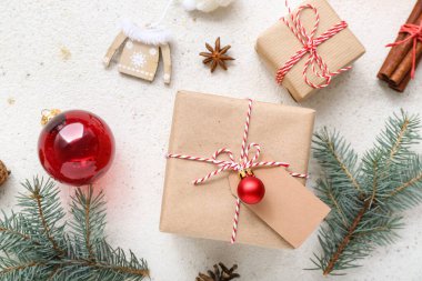 Süslemeli Noel ağacı dalları ve beyaz arka planda hediye kutuları