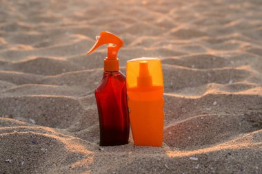 Kumsalda kumsalda güneş kremi şişeleri