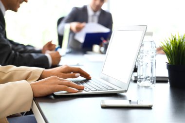 İş kadını konferans salonundaki masada dizüstü bilgisayarla çalışıyor.