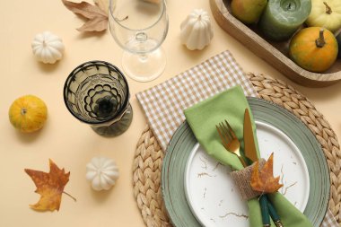 Mumlar ve bej arka planda sonbahar yaprakları ile şık masa ayarları