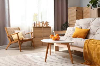 Beyaz kanepesi, sehpası ve koltuğu olan modern oturma odası.