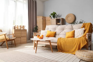 Kahve masasında beyaz kanepe ve portakallı modern oturma odası.