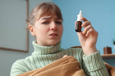 Evinde burun damlası olan hasta genç bir kadın, yakın plan.