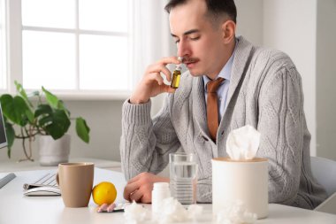 Ofiste burun damlası kullanan kötü bir işadamı.