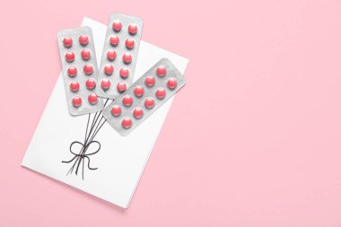 Kağıt kart ve pembe arka planda haplarla dolu su toplayıcı paketleri.