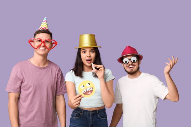 Mor arka planda komik kılık değiştirmiş genç arkadaşlar. 1 Nisan kutlamaları