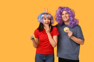 Kağıt tebessümlü ve sarı arka planda ıslık çalan komik görünümlü genç arkadaşlar. 1 Nisan kutlamaları