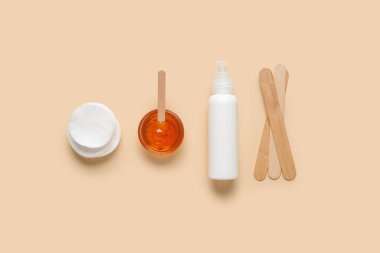 Şekerleme macunu, pamuk pedleri, krem ve spatulalar bej arka planda, üst manzara. Epilasyon kavramı