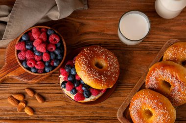 Tahta arka planda böğürtlen ve lezzetli simit tabağı.