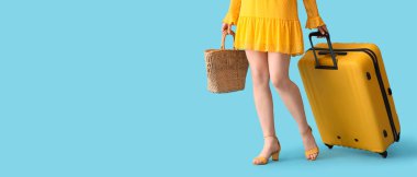 Çantası ve kumsal çantasıyla açık mavi arka planda mesaj için yeri olan bir kadın turist. Seyahat kavramı